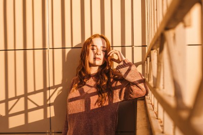Eine Frau in der Sonne auf einem Balkon
