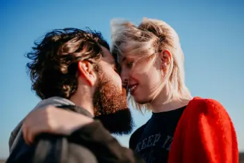Impfung schützt vor HPV: Mann und Frau küssen sich im Sonnenuntergang