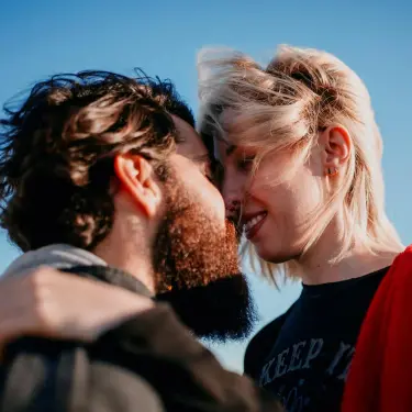 Impfung schützt vor HPV: Mann und Frau küssen sich im Sonnenuntergang