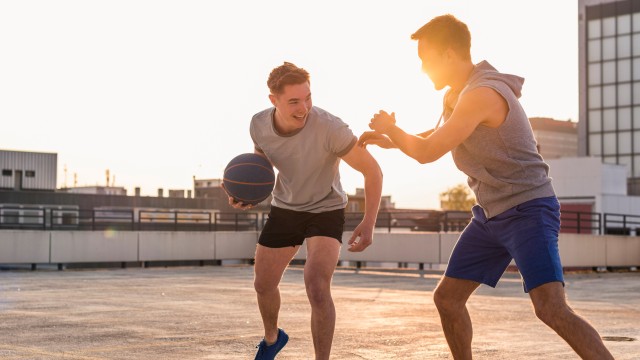 Zwei junge Männer spielen Basketball