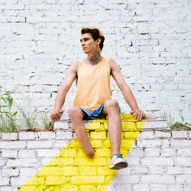 Person mit einem fehlenden Fuß sitzt auf einer Mauer