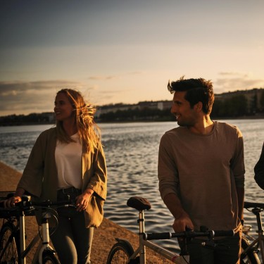 Drei junge Menschen schieben ihre Fahrräder