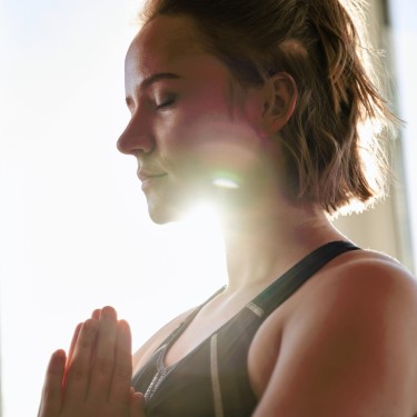 Konzentrationsstörungen: Junge Frau in der Yoga-Pose des Sonnengrußes